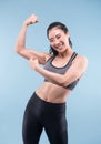 Cheerfully smiling asian sporty woman demonstrating biceps.
