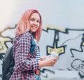 Cheerfully smiling Beautiful modern young female teenager Portrait with extraordinary hairstyle color in checkered shirt holding