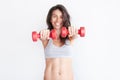 Cheerfully smiling sporty woman holding red dumbbells