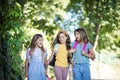 Three little girls walking trough nature with school bag on back