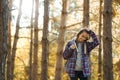 cheerfulness casual woman at fall forest with sun rays on background, feeling good hiking in woods Royalty Free Stock Photo