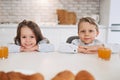 Cheerfulness. Pretty inspired little dark-haired girl and her brother smiling while they having breakfast