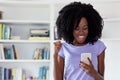 Cheering african american woman with mobile phone