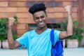 Cheering afro american freshman showing with backpack