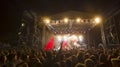 Cheering crowd in front of bright colorful stage lights