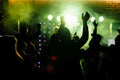 cheering crowd in front of bright yellow stage lights. Silhouette image of people dance in disco night club or concert Royalty Free Stock Photo