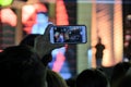Cheering crowd use smartphones to take record of artists that showing on stage Royalty Free Stock Photo