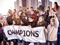 Cheering fans in stadium holding champion banner. Royalty Free Stock Photo