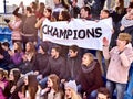 Cheering fans in stadium holding champion banner. Royalty Free Stock Photo