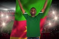 Cheering football fan in green jersey holding cameroon flag Royalty Free Stock Photo