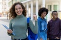 Cheering german female student with backpack and group of international students Royalty Free Stock Photo