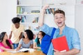 Cheering german male student with group of other students