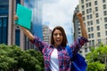 Cheering hispanic female student in city