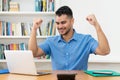 Cheering hispanic hipster man with beard working at computer