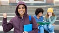 Cheering hispanic male student with hoody and group of caucasian and african american young adults Royalty Free Stock Photo