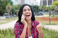 Cheering latin american young adult woman at mobile phone Royalty Free Stock Photo