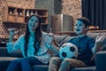 Cheering little boy and his mother watching a soccer game on couch Royalty Free Stock Photo