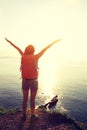 Cheering woman backpacker open arms on seaside Royalty Free Stock Photo