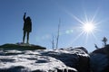 Cheering woman hiker open arms at mountain peak backlit with heavy lensflare and ice crystalls in the foreground. Royalty Free Stock Photo