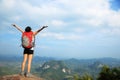 Cheering woman hiker open arms at mountain peak Royalty Free Stock Photo