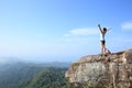 Cheering woman hiker open arms at mountain peak Royalty Free Stock Photo