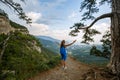 Cheering woman hiker open arms at mountain peak, Young girl spreading hands with joy and inspiration with backpack on Royalty Free Stock Photo