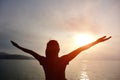 Cheering woman open arms on beach