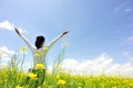 Cheering woman open arms at cole flower field