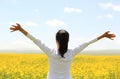 Cheering woman open arms at cole flower field Royalty Free Stock Photo