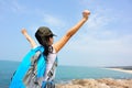 Cheering woman open arms at seaside rock Royalty Free Stock Photo