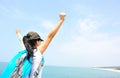 Cheering woman open arms at seaside rock Royalty Free Stock Photo