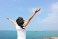 Cheering woman open arms at seaside rock Royalty Free Stock Photo