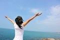 Cheering woman open arms at seaside rock Royalty Free Stock Photo