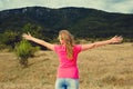 Cheering woman open arms to mountain