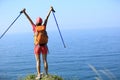 Cheering young woman hiker open arms on seaside mountain Royalty Free Stock Photo