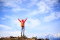 Cheering young woman hiker open arms to beautiful snow mountain Royalty Free Stock Photo