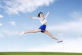 Cheerleader girl jumps and doing splits in the field