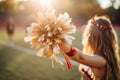 Cheerleader girl with a pompon on the football field