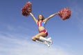 Cheerleader Jumping Midair With Pom Poms Royalty Free Stock Photo