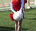 Cheerleader standing with pompoms behind her Royalty Free Stock Photo