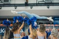 cheerleaders holding a girl up doing a split in the air, indoors Royalty Free Stock Photo