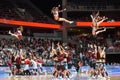 Cheerleaders jumping in the air, during performance at half time. Basketball game.