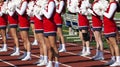 Cheerleaders with pom poms cheering at high school football game Royalty Free Stock Photo