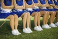 Cheerleaders Sitting With Arms Crossed On Bench In Field