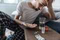 Cheerless depressed man holding a palm with three pills Royalty Free Stock Photo