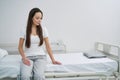 Cheerless female patient seated alone in her ward