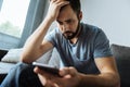 Cheerless gloomy man holding his smartphone Royalty Free Stock Photo