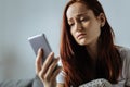 Cheerless young woman looking at her phone Royalty Free Stock Photo