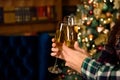 Cheers. Close up photo of two people holding glasses of shampagne on xmas. Royalty Free Stock Photo