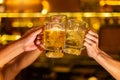 Cheers, Group of happy friends drinking and toasting beer at brewery bar restaurant, mugs of beer